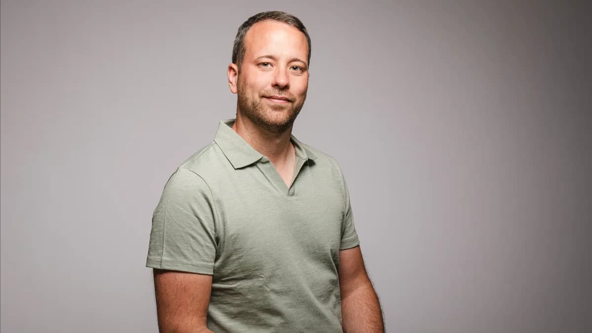 Christoph Brünnet im grünen Poloshirt vor hellgrauem Grund